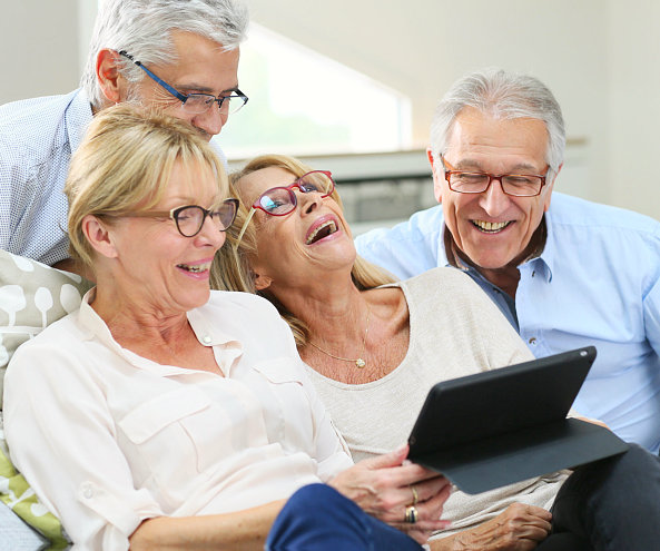 seniors laughing and watching at the tablet